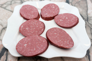 Slices of sucuk sujuk sausage isolated on white background .