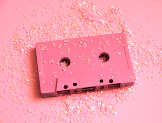 Pink audio cassette tape in glitters. Party concept minimal photo in 90s style