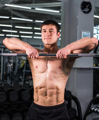 Fototapeta na wymiar Handsome bodybuilder man with big muscles in the gym