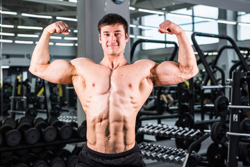 Fototapeta na wymiar Muscular bodybuilder guy in gym