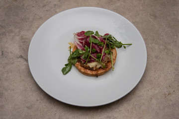 Pastry with mince meat and cheese topped with watercress and red cabbage