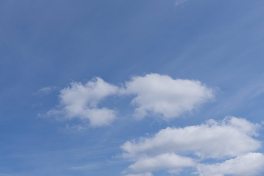 Deep blue sky on sunny day with clouds .