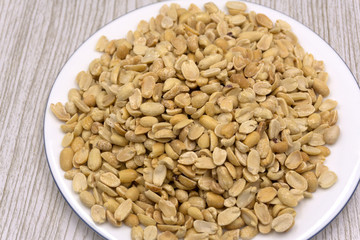 Roasted peanuts, salt, put in a cup. Brown was placed on the wooden floor.