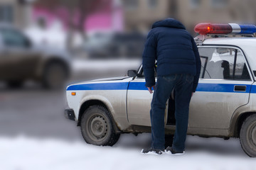 a police officer stands near the traffic police car and watches the pedestrian areas of police traffic police. © baon
