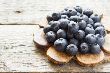 Blueberries on old wooden dishes, space for text
