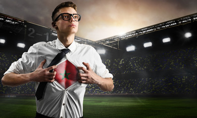 Morocco soccer or football supporter showing flag under his business shirt on stadium.