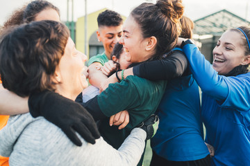 Football players jubilant and hugging on pitch