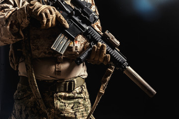 Special forces soldier with rifle on dark background