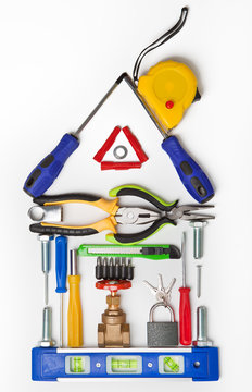 Various working tool for repair and construction laid out in the form of a house on a white background