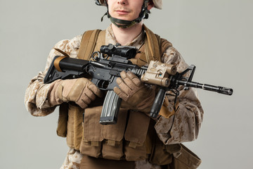 Soldier in camouflage holding rifle