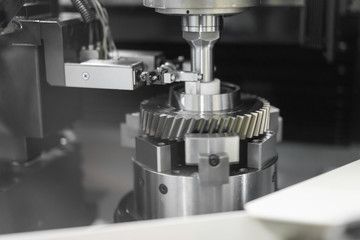 Fototapeta na wymiar High precision CNC machining center working, operator machining and grinding automotive sample gear part process