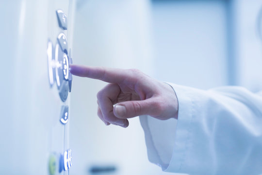 Person using control panel of CT scanner, close-up