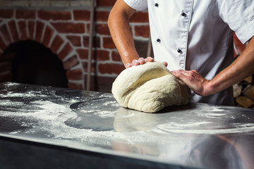 chef making dough for pizza. Man hands preparing bread. Concept of baking and patisserie
