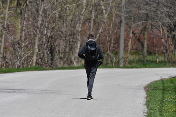 A young man is walking alone on Toronto-island