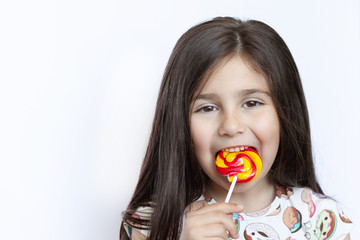 Beautiful cute little girl eating lollipop