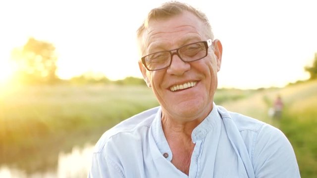 Carefree retired man smiling looking at camera. Portrait of an elderly man wearing glasses. Happy holidays. Father's Day