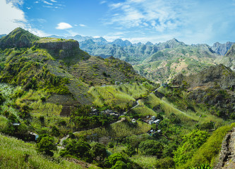 Cape Verde. Gorgeous panoramic view of famous fertile Paul Valley. Agriculture terraces of sugarcane in vertical valley sides, people dwellings, rugged peaks and motion clouds on horizon
