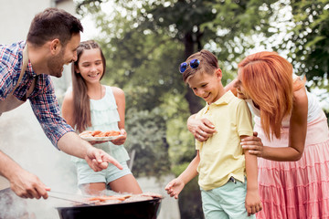 Young family make barbecue at their home