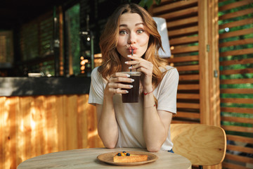 Portrait of a smiling young girl drinking lemonade
