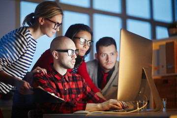 Group of designers using computer for work. They are working till night
