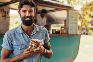 Man having food truck burger - obrazy, fototapety, plakaty