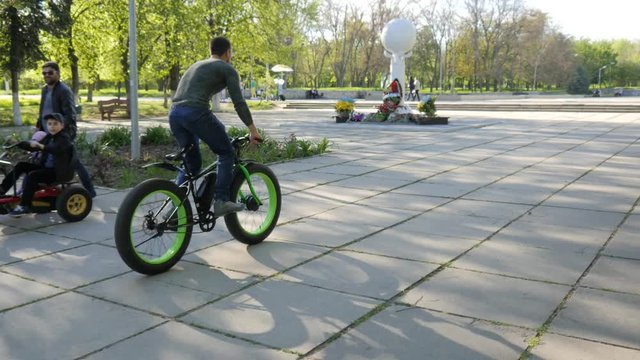 Man riding Electric bicycle in a green park public place