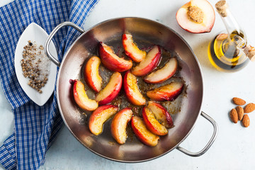 fried pieces of peaches in a frying pan on the table. Cooking.