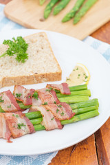 Fresh Young Asparagus Wrapped in Prosciutto Meat and Grilled on pan

