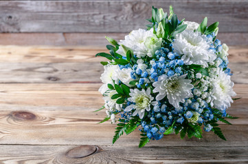 Wedding bouquet of white and blue chrysanthemums on a wooden background