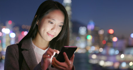 Business woman read on smart phone in city at night