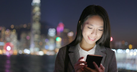 Woman use of cellphone for online at outdoor in the evening