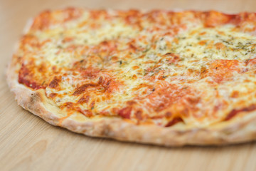 Closeup on traditional fresh pizza, top side view wooden background