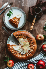 flat lay with piece of homemade apple pie, cutlery and coffee maker arranged on wooden surface