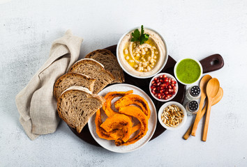 vegan appetizer snack from hummus of white cannellini beans and baked pumpkin on a serving board. Just great food