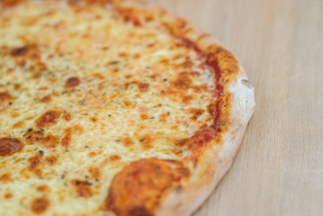 Closeup on traditional fresh pizza, top side view wooden background