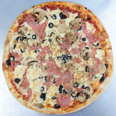 Closeup on traditional fresh pizza, top side view wooden background