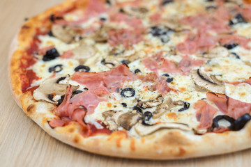 Closeup on traditional fresh pizza, top side view wooden background