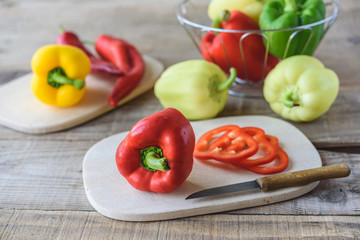 Selection of colorful peppers on wooden table. Cooking fresh food background.