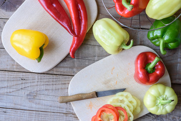 Selection of colorful peppers on wooden table. Cooking fresh food background.