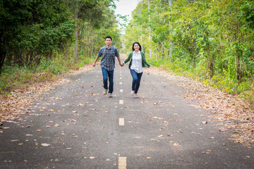 Obraz premium Couples holding hands running down the street.