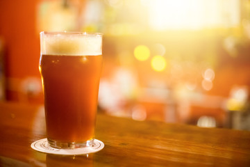 Dark kraft beer on the wooden bar with copy space for text. Evening friday party