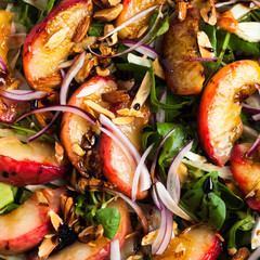 summer, very tasty salad with peaches, sweet onions and arugula with almonds on a table in a plate. simple healthy recipe