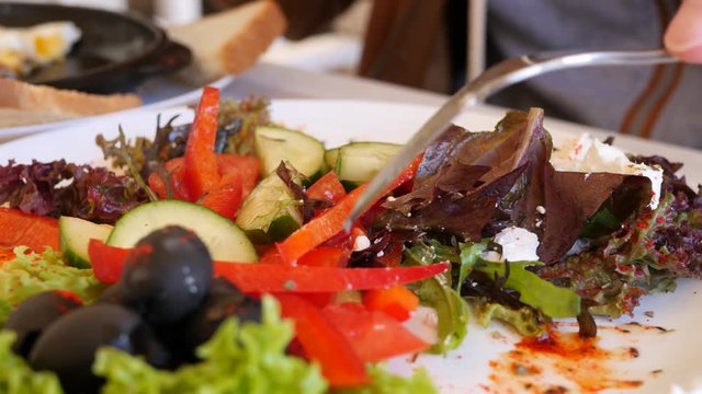 Young man in restaurant eating healthy food vegetable salad during breakfast