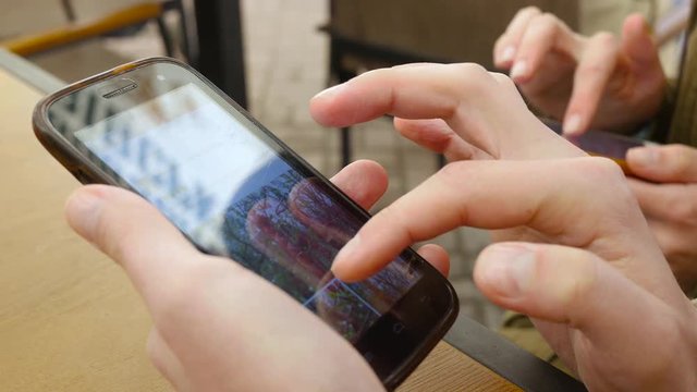 Young couple fingers sliding smartphone touchscreen surfing in social media
