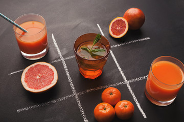 Tic-tac-toe with oranges and spices on black background