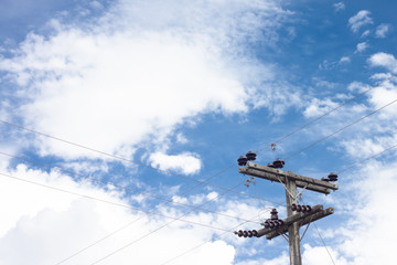 Electric pole and cable under blue sky.