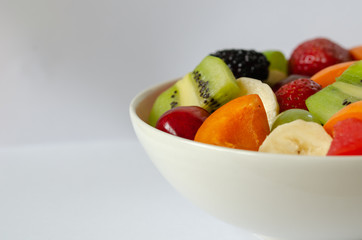 Fresh colorful fruit salad on white background.Healthy nutrition, diet concept.