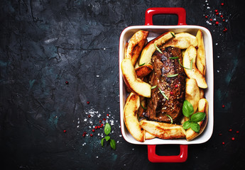 Pork tenderloin baked with quince on a baking sheet, gray background, top view