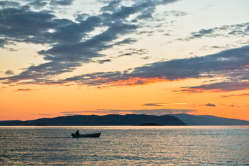 Sun is setting behind Skiathos island, view from Kastani Mamma Mia beach, island of Skopelos, Greece