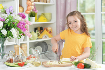 Obraz na płótnie Canvas Funny little girl cooking